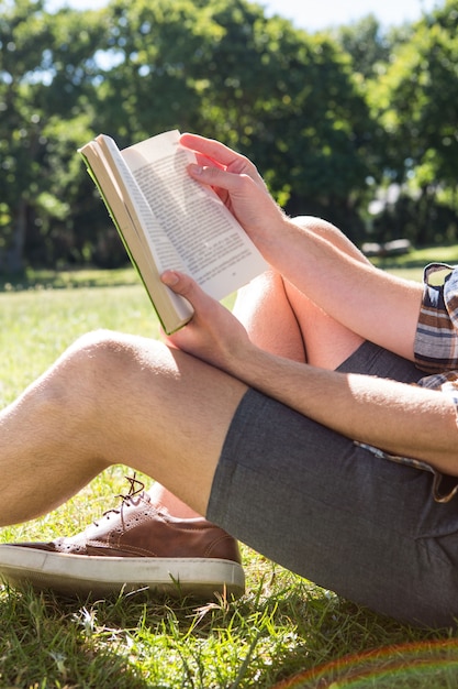 Foto libro de lectura guapo inconformista en el parque