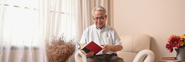 Libro de lectura del hombre mayor asiático y quedarse solo en casa. Estilo de vida en edad de jubilación.