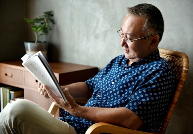 Libro de lectura del hombre mayor en casa