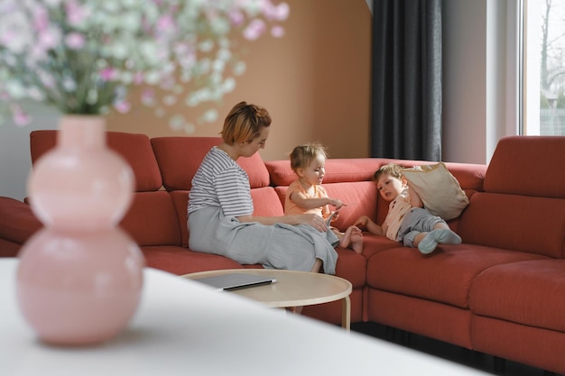 Libro de lectura de la madre con dos niños en el sofá