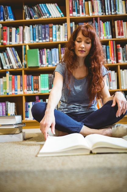 Foto libro de lectura madura del estudiante en biblioteca