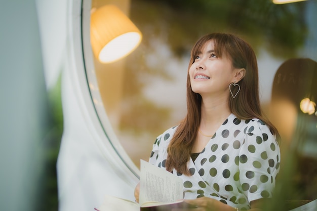 Libro de lectura de mujer de Asia con felicidad en el tiempo libre