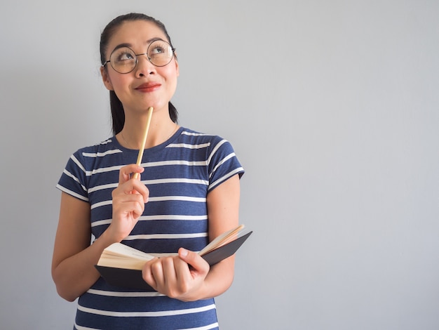 Libro de lectura de la mujer asiática y pensando en ideas.