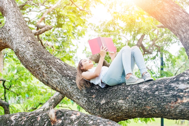 Libro de lectura de mujer asiática sola en el parque el día de la primavera. Relax y recreación. Actividad al aire libre y estilo de vida en vacaciones.