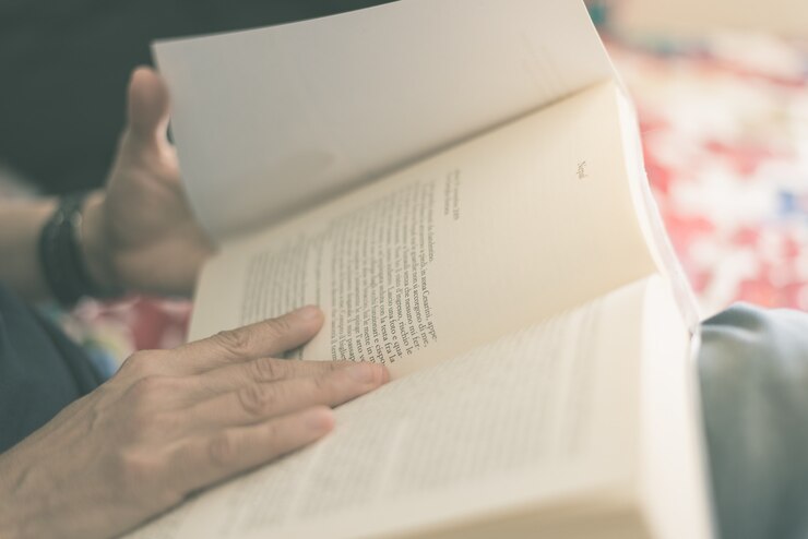 Foto libro de lectura de mujer. enfoque selectivo, de cerca. cruz procesada con efecto de película vintage. tonos cálidos