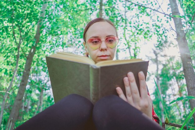 Libro de lectura de mujer hermosa joven en espacio abierto