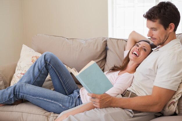 Libro de lectura relajada de la pareja en el sofá