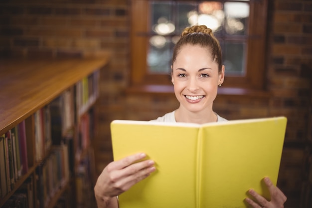 Libro de lectura rubio del profesor en la biblioteca