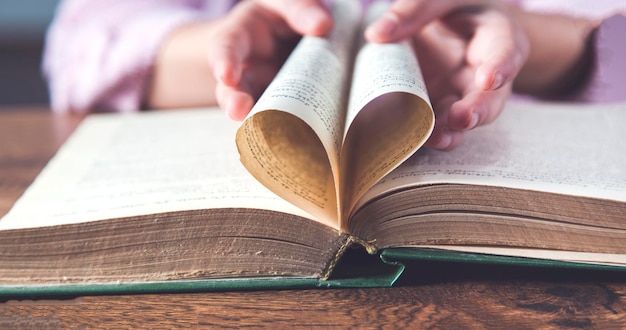 Libro de mano de mujer con corazón de página