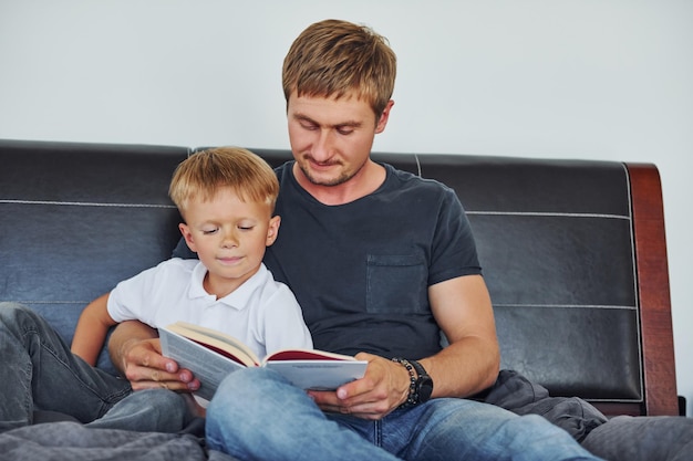 Con el libro en las manos, padre e hijo están juntos en casa