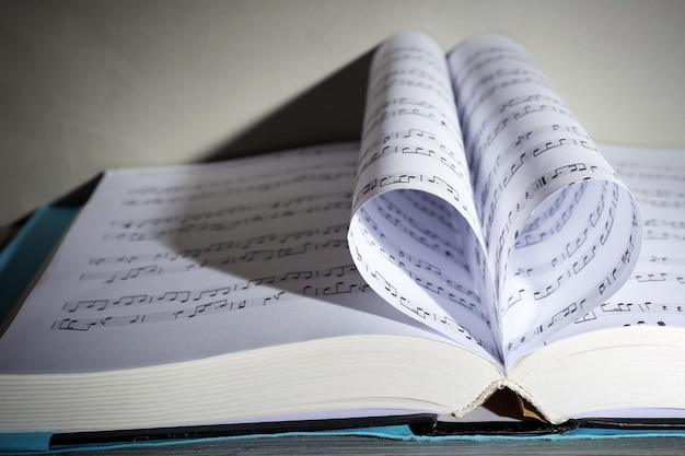 Libro páginas curvadas en forma de corazón sobre fondo gris