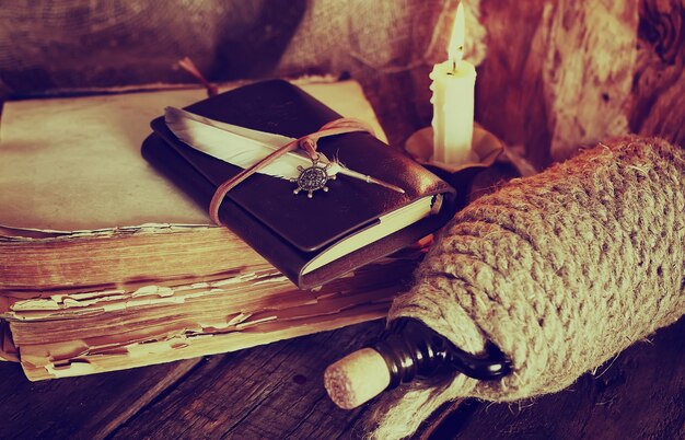 Foto libro de plumas y cuero de objetos retro con luz de velas