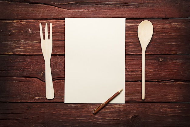 Foto libro de recetas en blanco sobre mesa de madera