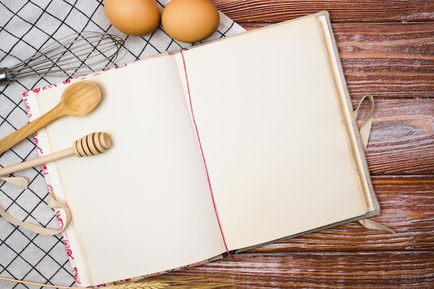 Foto libro de recetas vintage en blanco y en la mesa de madera de la cocina closeup lugar para el texto vista superior