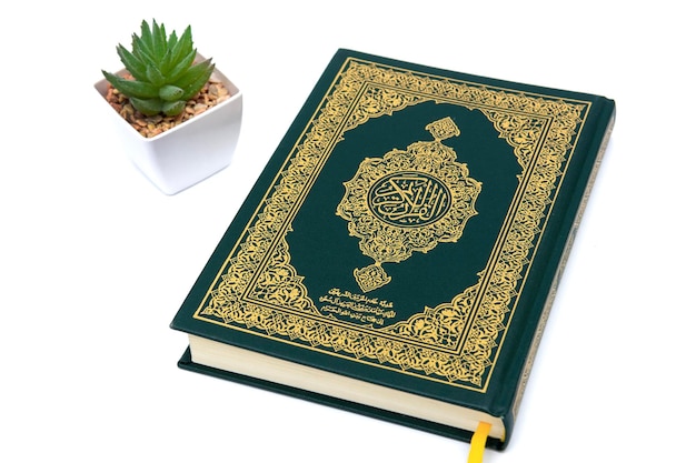 Libro sagrado musulmán al corán aislado en fondo blanco con plantas