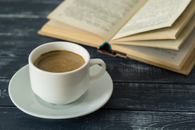 Un libro y una taza de bebida caliente, café.