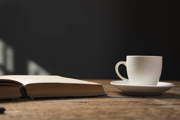 Libro y una taza de café en una mesa de madera