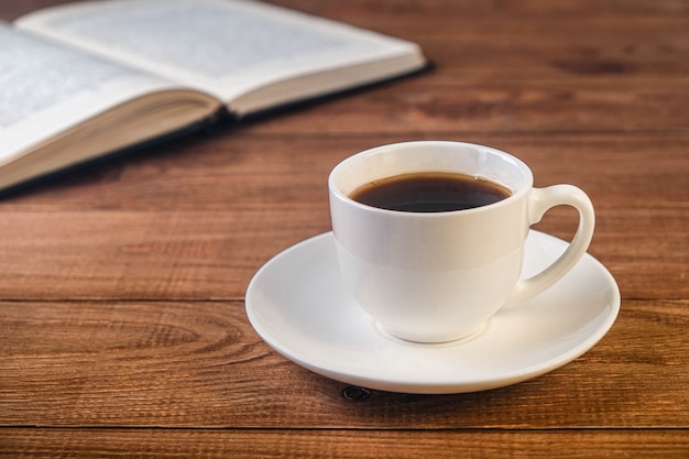 Libro y taza de café sobre superficie de madera