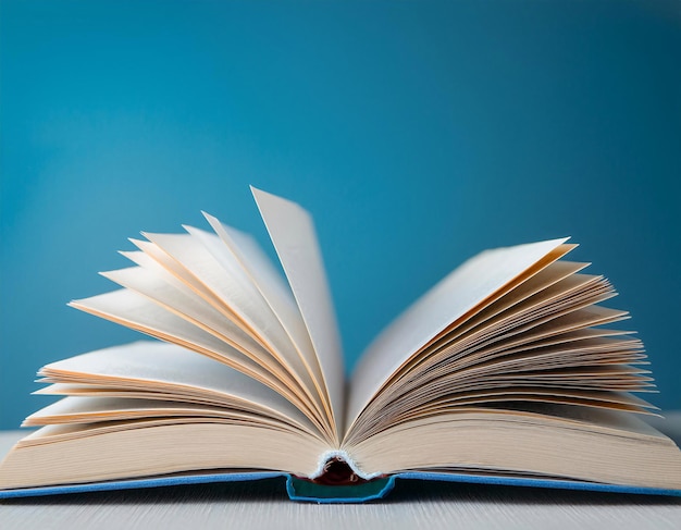 Un libro de texto abierto con páginas a mitad de vuelta colocadas en una mesa El libro de tapa dura representa conceptos
