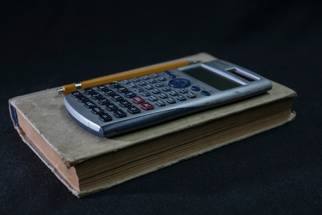 Libro de texto de matemáticas, lápiz y calculadora.