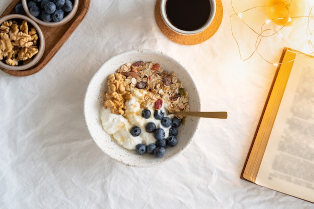 Libro de vista superior y desayuno de estilo de vida saludable con granola muesli y yogur