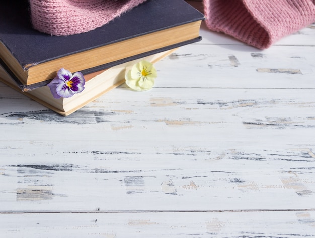 Libros antiguos y flores en la mesa de madera clara. Concepto de lectura. Copia libre de espacio.