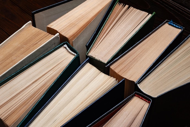 Libros antiguos Grupo de viejos libros de tapa dura abiertos usados en polvo sobre fondo de madera oscura