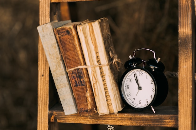 Libros antiguos en el reloj de estante