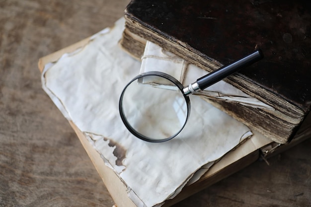 Libros antiguos sobre una mesa de madera y una lupa