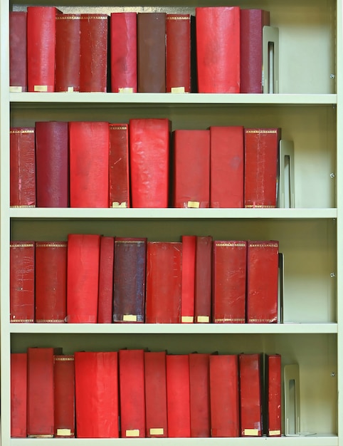 Libros antiguos de tapa dura rojos en estantería