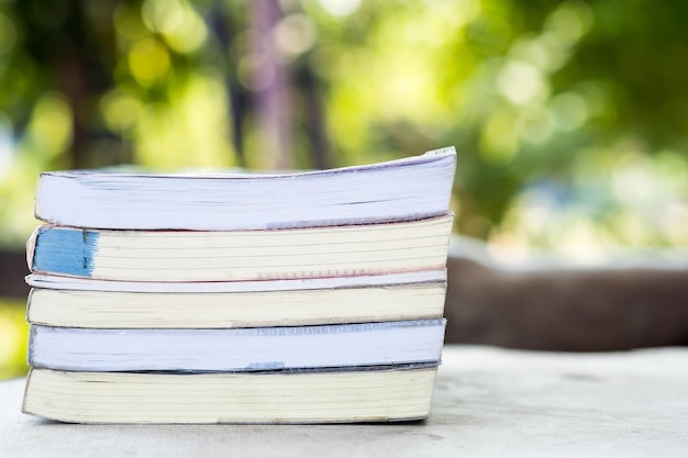 Libros apilados en jardín borroso