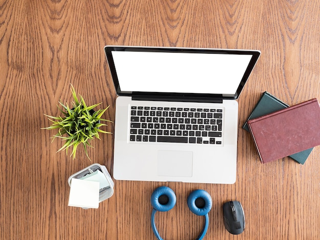 Libros, auriculares y portátil sobre una mesa. Vista superior