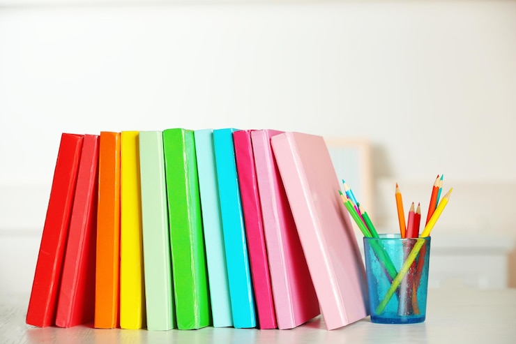 Foto libros coloridos y lápiz sobre la mesa en la habitación.