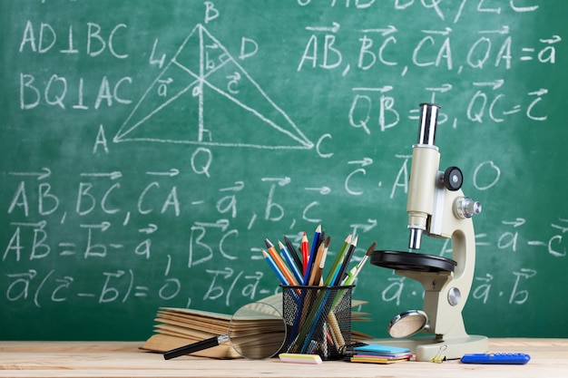 Libros de concepto de educación y ciencias en el escritorio del maestro en la pizarra del auditorio en el fondo