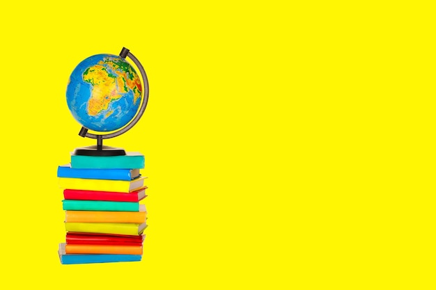 Libros un globo sobre un fondo amarillo Concepto de regreso a la escuela Espacio para texto