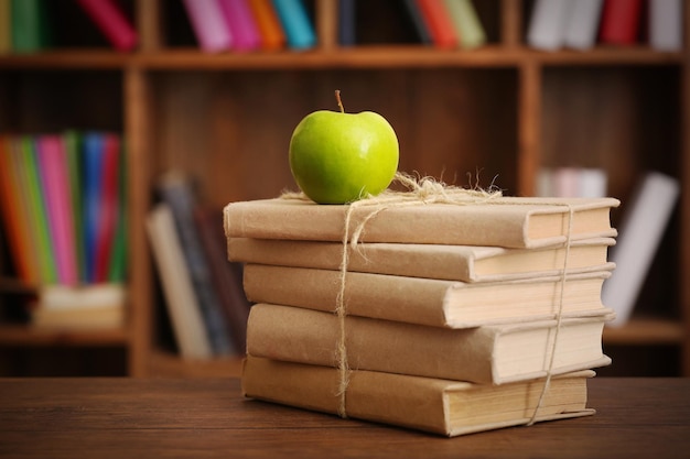 Libros y manzana en el primer plano de la mesa