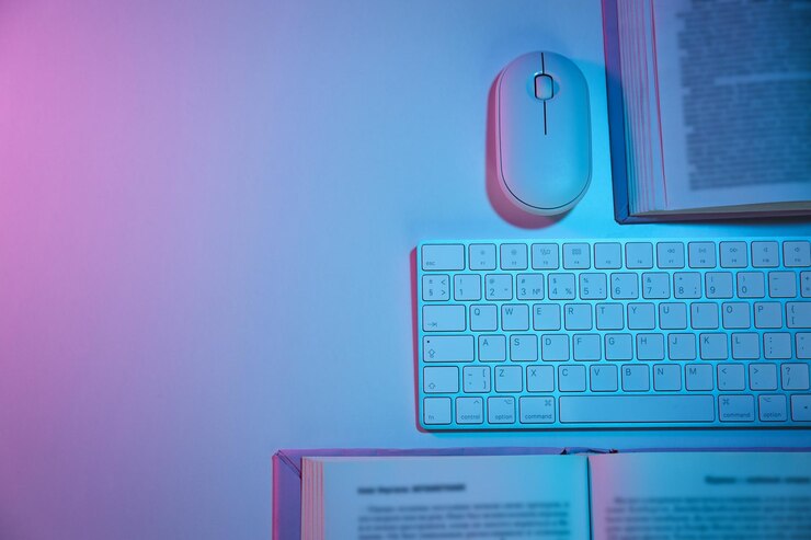 Foto libros con un ratón de computadora y un teclado en un fondo claro