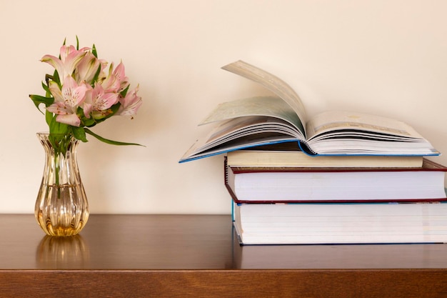 Libros sobre la mesa con florero