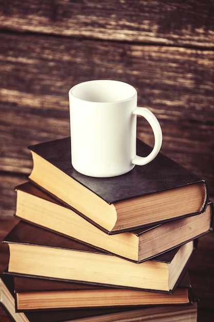 Libros y taza de café en la mesa de madera