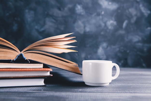 Libros y una taza de café en la mesa.