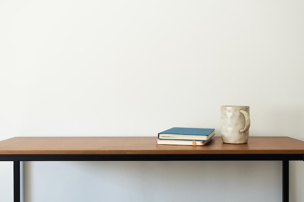 Libros y taza en escritorio de madera interior estético minimalista Planificador espacio de trabajo de escritor de diario personal