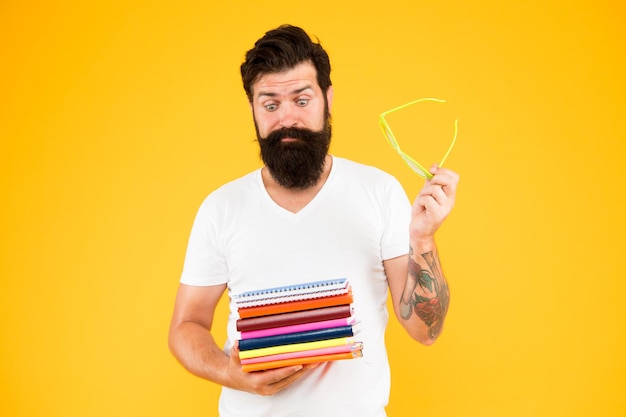 Libros de texto universitarios Hipster creativo Diario personal Estudiante freak Educación para adultos Hipster estudiante excéntrico sostener libros de pila Estudiar duro Cursos de idiomas Comprar papelería Estudiante adulto