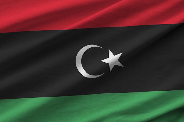 Libyen-Flagge mit großen Falten, die in der Nähe unter dem Studiolicht im Innenbereich winken Die offiziellen Symbole und Farben im Banner