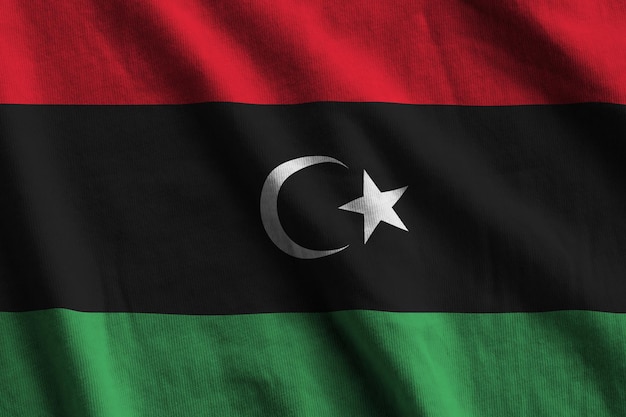 Libyen-Flagge mit großen Falten weht aus nächster Nähe unter dem Studiolicht im Innenbereich die offiziellen Symbole und Co