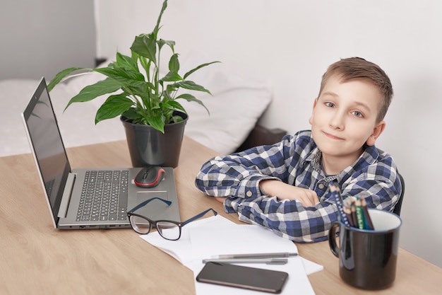 Lição on-line em casa, distância social durante quarentena, auto-isolamento, conceito de educação on-line, estudante em casa. rapaz, aprendendo a língua on-line, usando o laptop, educação a distância. rapaz estudante, escola