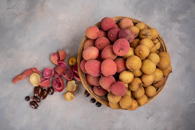 Lichi y longan en cesta sobre fondo de piedra gris Frutas exóticas en bandeja en casa