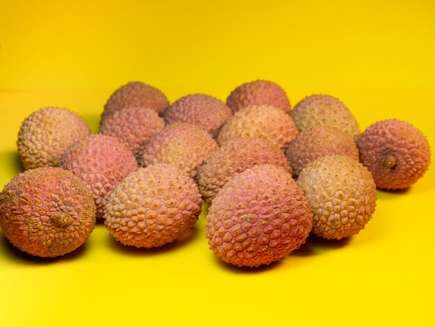 Lichi sobre la mesa Ciruela china sobre un fondo amarillo Fruta madura de Asia