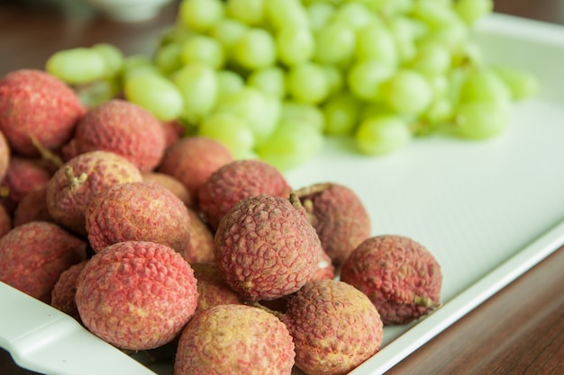 Lichi y uvas frescas en una bandeja