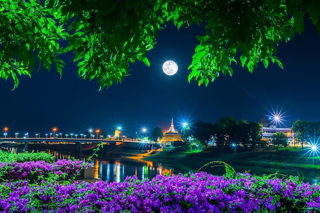 Licht auf der Naresuan-Brücke und Chedi von Wat Ratchaburana und Prang Wat Phra Si Rattana Mahathat auch umgangssprachlich am Nan-Fluss und dem Park und Vollmond in der Nacht in PhitsanulokThailand