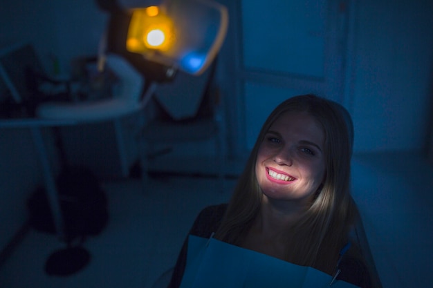Foto licht, das über die zähne des weiblichen patienten in der klinik fällt